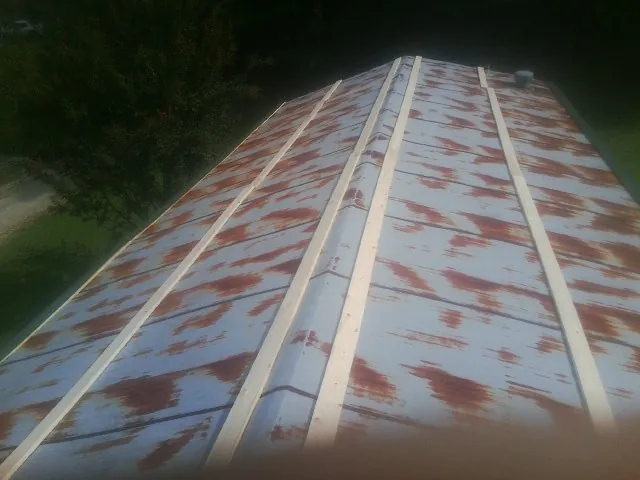Rusted metal roof panels with new wood purlins before replacement — Storm Damage Roof Repair in Inkster by Roofing Brothers