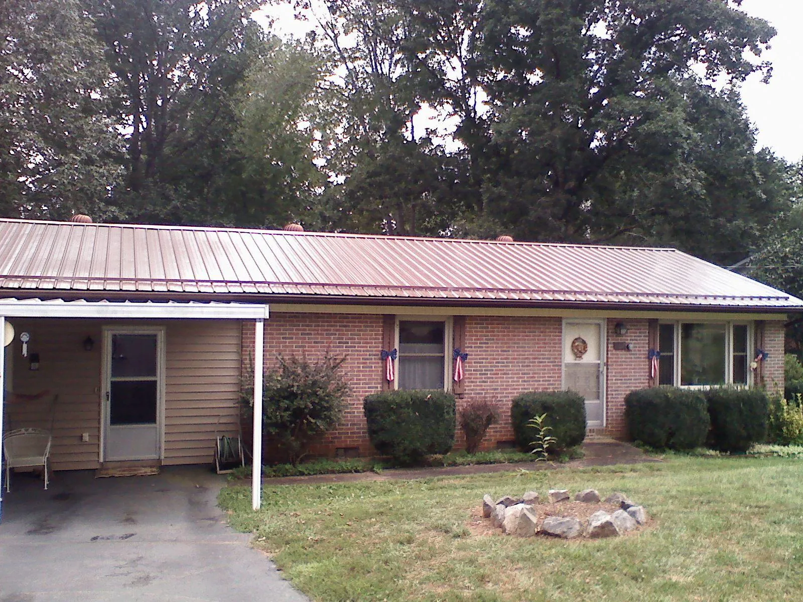 Bronze metal roof and carport on a brick ranch home — Roof Repair work by our crew in Inkster