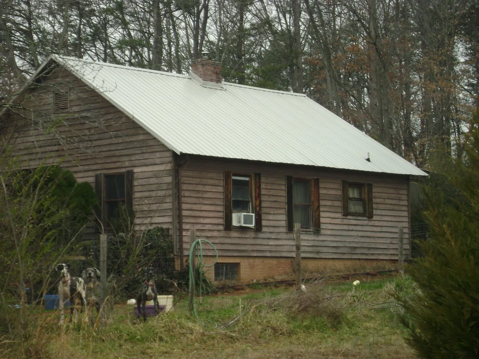 White metal roof on an old wood sided farmhouse, from a Metal Roof Installation job in Inkster